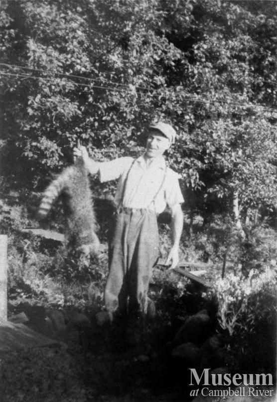 George Nunns with racoon that he trapped